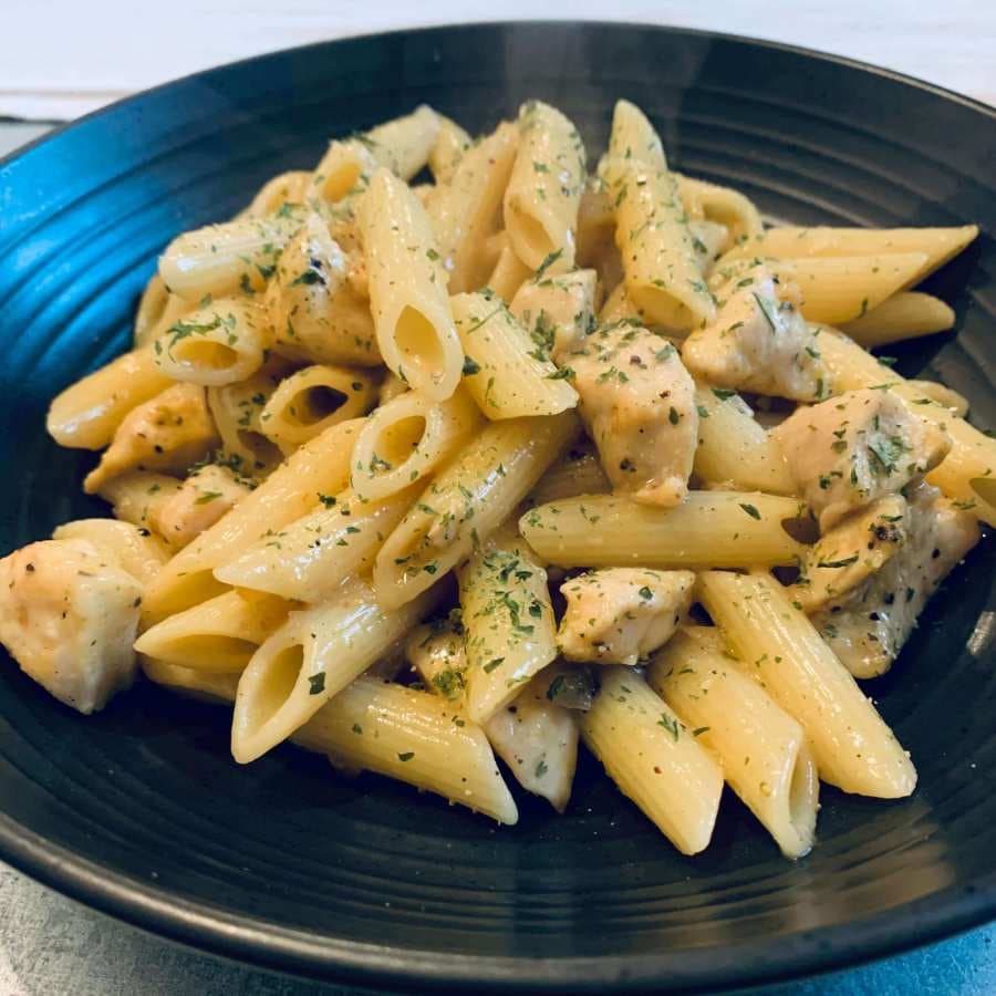 Tangy lemon chicken pasta topped with coriander leaf.