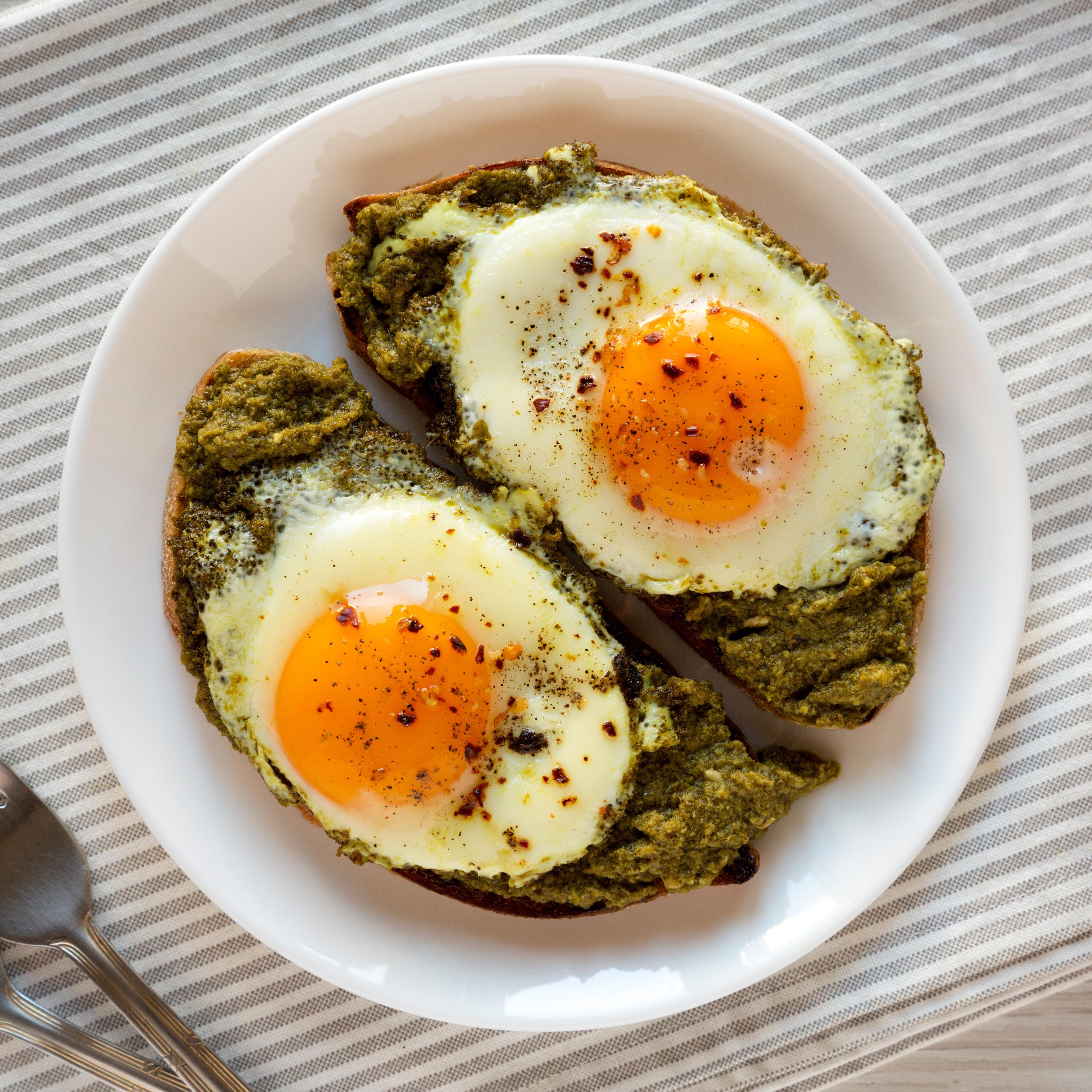 Pesto egg toast. Runny eggs with black pepper on a pesto base. 