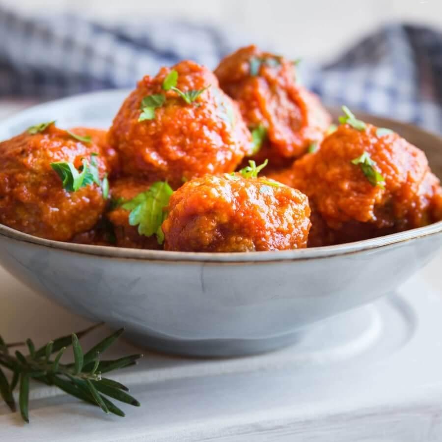 Homemade albondigas in a rich traditional tomato sauce topped with coriander leaf.