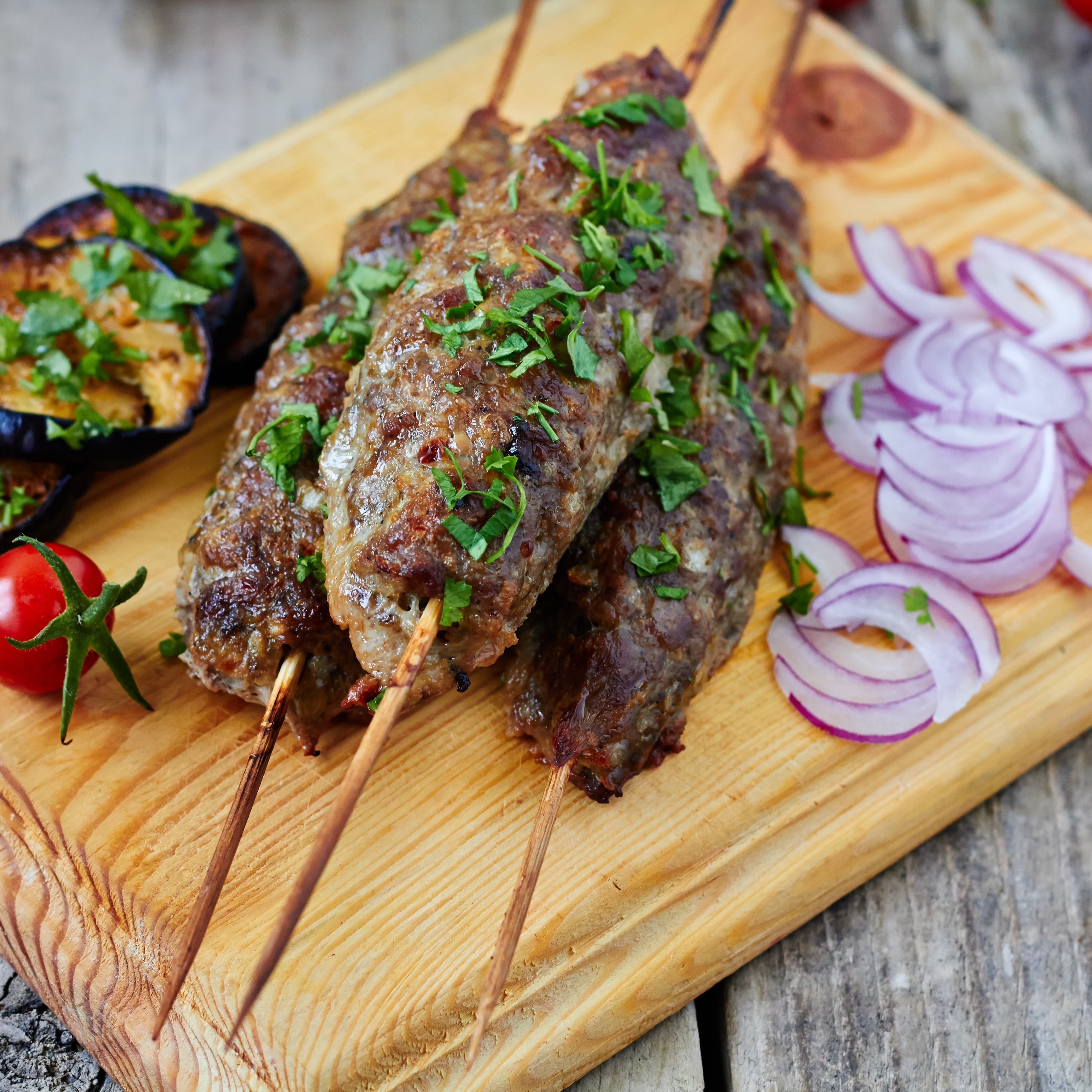 Organic mint lamb kofta skewers topped with parsley.