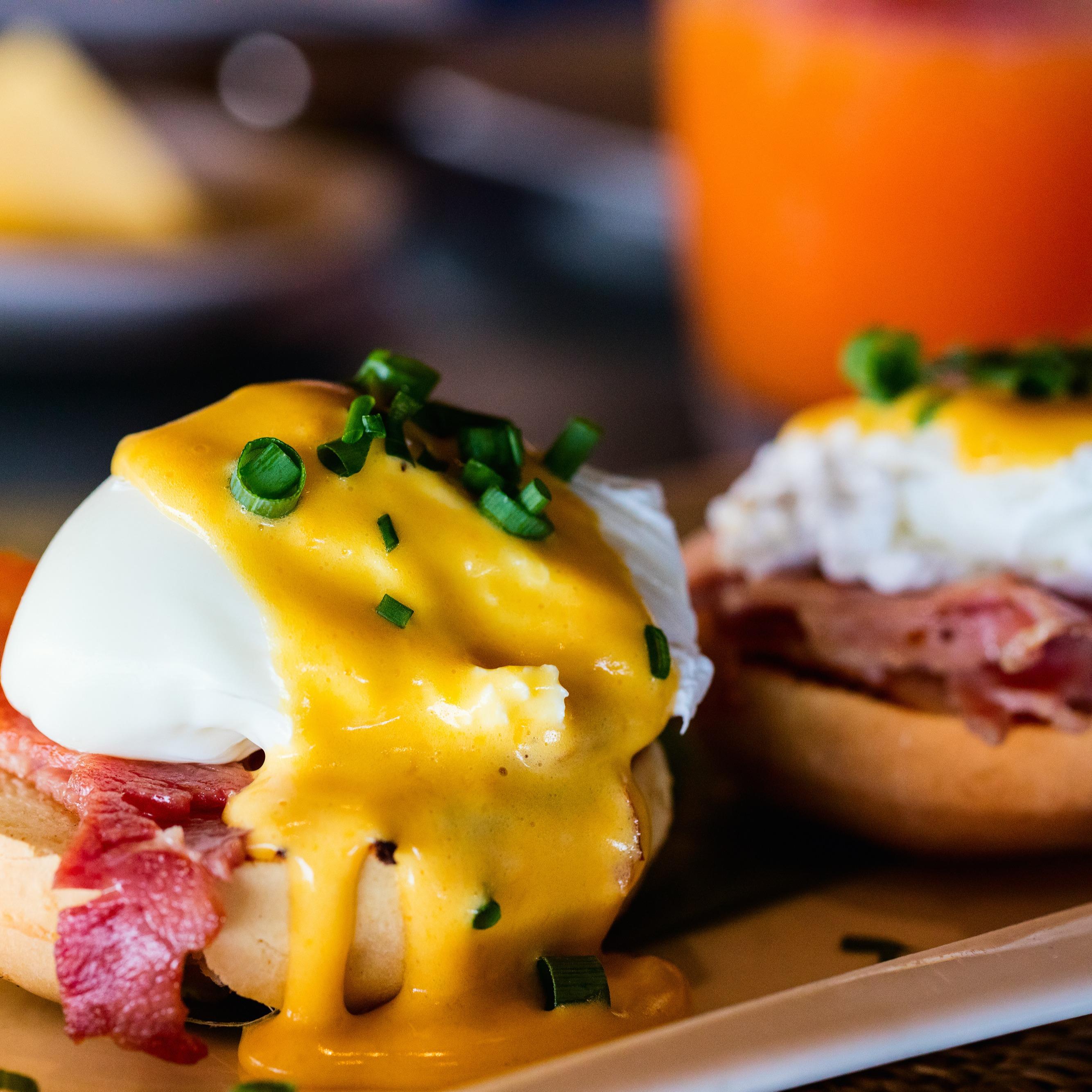 Tangy eggs benedict with smoky bacon and a runny poached egg topped with spring onions