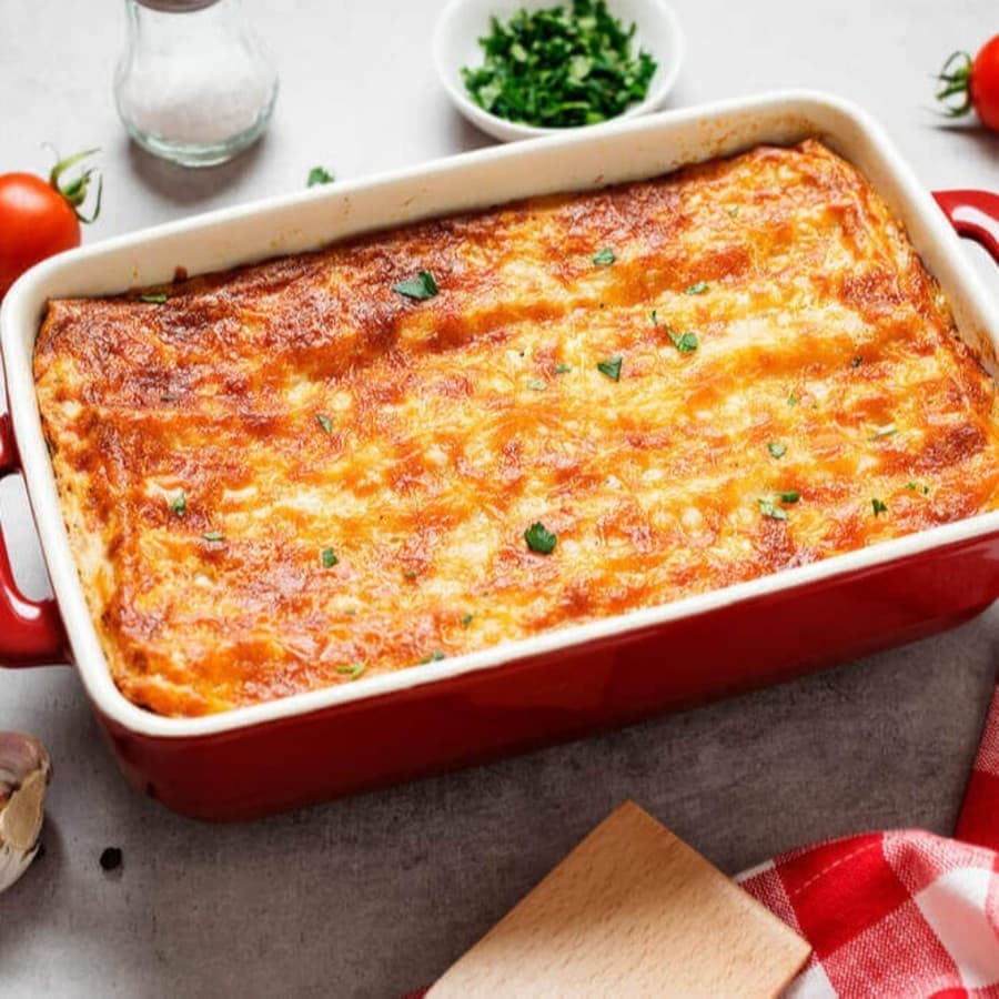 Classic Italian homemade ground beef lasagne topped with melted cheese and garnished with flat leaf parsley.